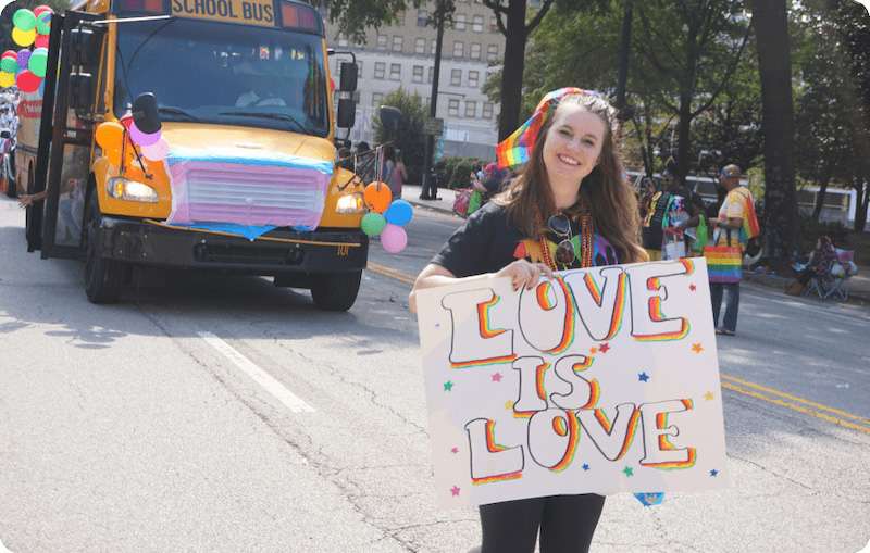 Staff at Pride Parade holding Love is Love sign